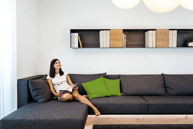 HARTLHAUS-Fertighaus-Loxone-Lounge Frau im Showhome von Loxone in der Lounge
